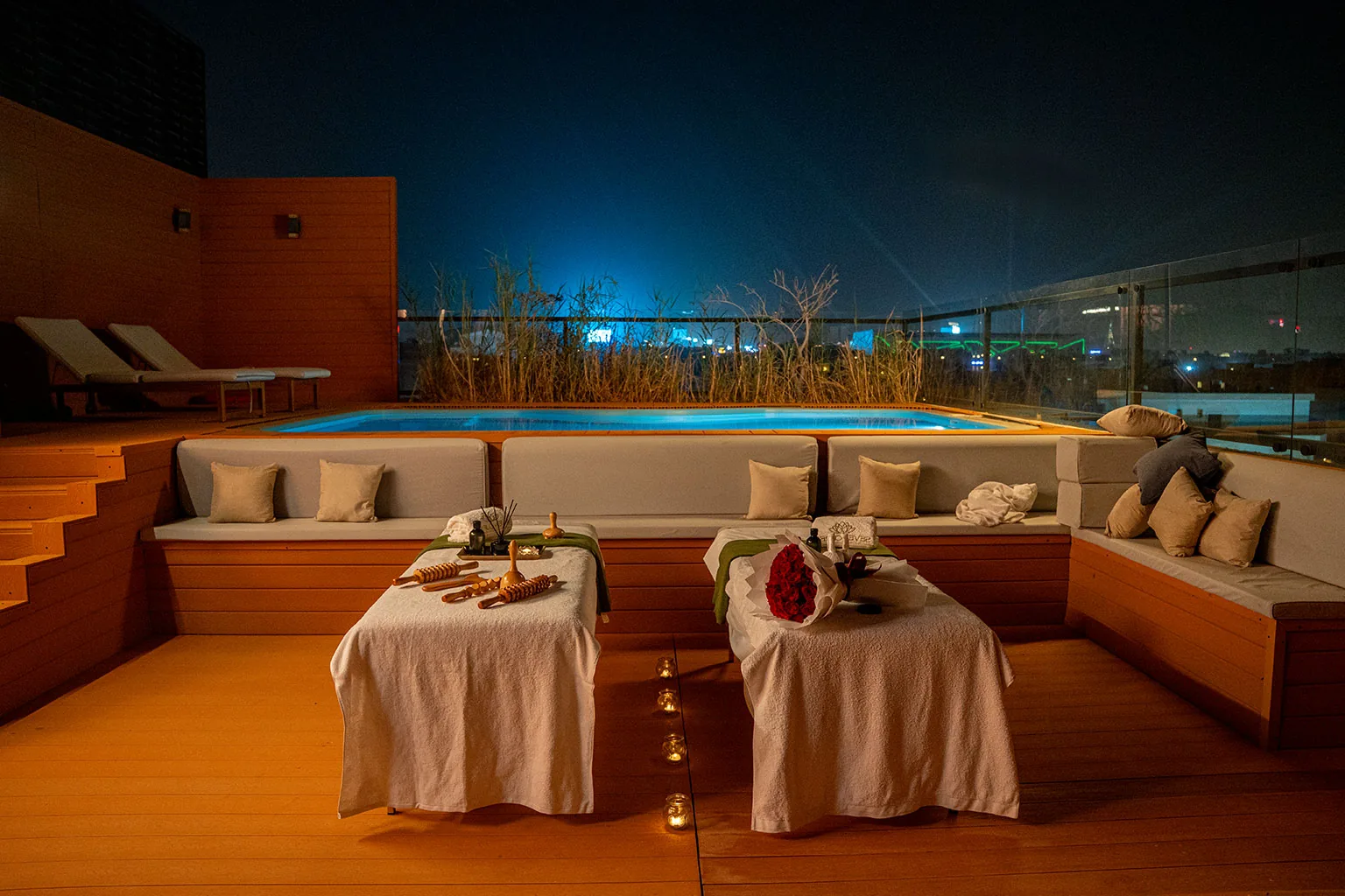 Two massage beds beside a pool at night, prepared by SEVEN CURES for a private spa experience in Riyadh